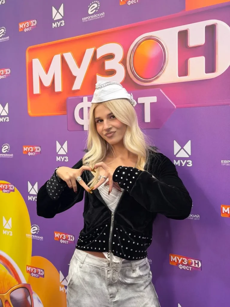 SteshOK показывает сердце руками на фоне баннера «Музон Фест»